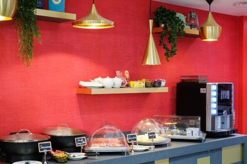 a counter with some food on a red wall at Hôtel Lucien & Marinette in Paris