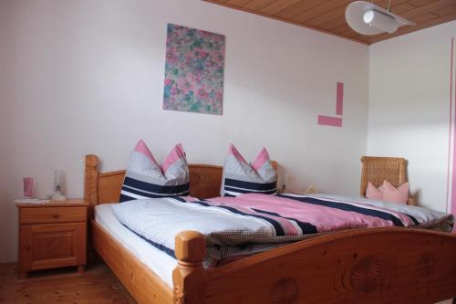 a bedroom with a wooden bed with shoes on it at Ferienwohnung Gegenfurtner in Böbrach