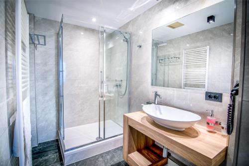 a bathroom with a sink and a shower at Hotel Wilder Mann in Rückersdorf