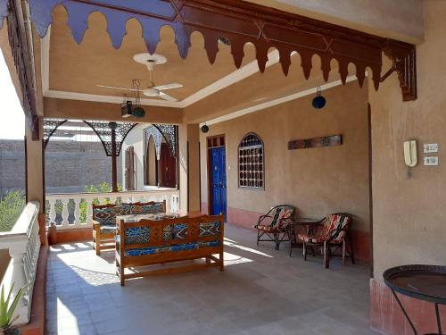 a porch with benches and a table and chairs at Villa Nile House Luxor in Luxor
