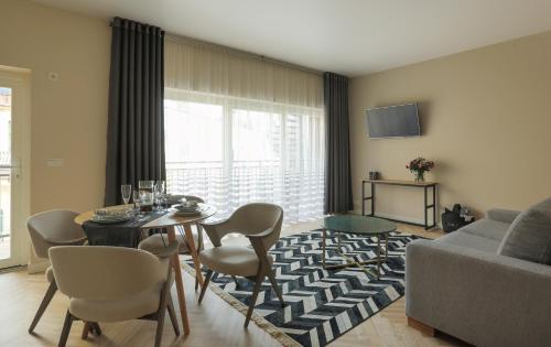 a living room with a table and chairs and a couch at Dönhoff Residence in Pärnu