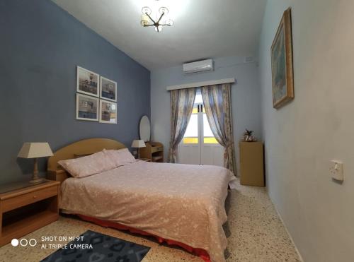 a bedroom with a bed and a window at Arzella Holiday Home in Birżebbuġa