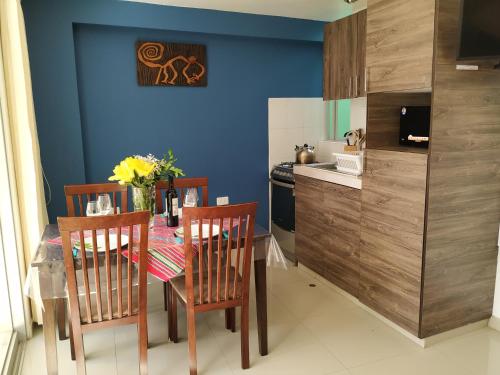 a kitchen with a table and chairs and a blue wall at La Casa de Justi in Huancayo