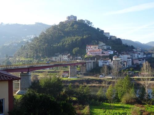 a bridge over a town with a mountain at Hospedaria Lampião in Penacova