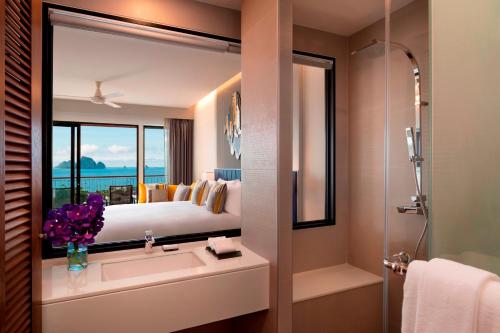 a bathroom with a sink and a bed and a mirror at Avani Ao Nang Cliff Krabi Resort in Ao Nang Beach