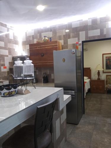 a kitchen with a counter with a refrigerator in it at Los Balcones Puerto Morelos in Puerto Morelos