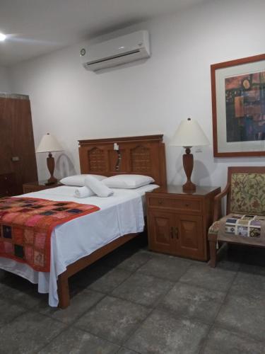 a bedroom with a large bed and a chair at Los Balcones Puerto Morelos in Puerto Morelos