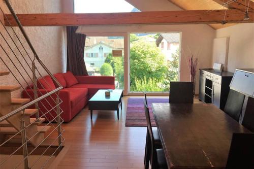 Una sala de estar con un sofá rojo y una mesa. en Whole large 3 levels apartment, en Port-Valais
