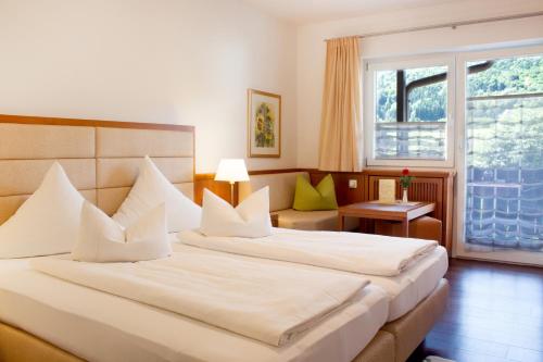 a hotel room with two beds and a window at Gasthof Fischerstüberl in Rottau