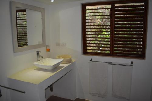 a white bathroom with a sink and a window at Villa Noria in Las Terrenas