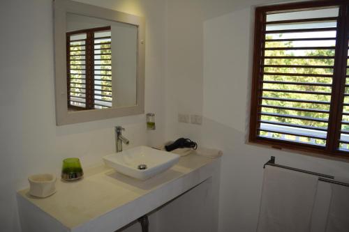 a white bathroom with a sink and a mirror at Villa Noria in Las Terrenas