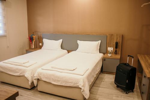 a bedroom with two beds and a suitcase at Hayat Palas in Erzincan