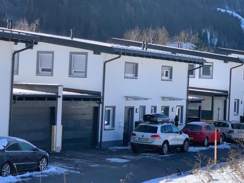 un edificio bianco con auto parcheggiate in un parcheggio di Haus Schladming a Schladming
