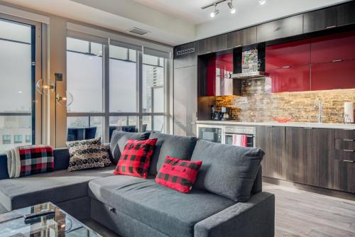 a living room with a gray couch with red pillows at Luxury Adventure CN Tower/MTCC/Scotiabank Arena in Toronto