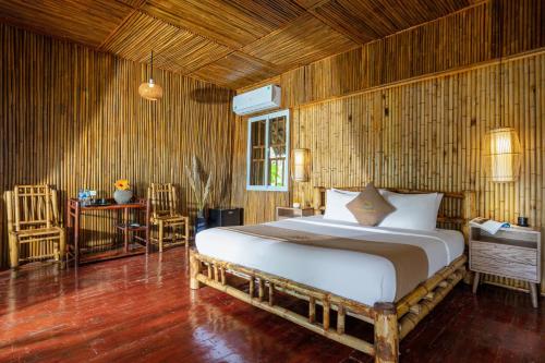 a bedroom with a bed and a table and chairs at An's Eco Garden Resort in Ninh Binh