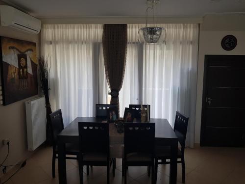 a dining room table and chairs in a room at VILLA BY THE SEA VRAVRONA LOUTSA(NEAR THE AIRPORT&METROPOLITAN) in Athens