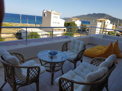 a patio with chairs and a table on a balcony at VILLA BY THE SEA VRAVRONA LOUTSA(NEAR THE AIRPORT&METROPOLITAN) in Athens
