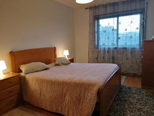 a bedroom with a large bed and a window at Apartamento Rua da Amizade in Felgueiras