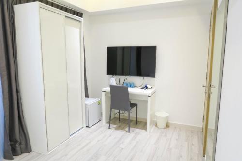 a white room with a desk and a television at RR Cozy Studio & Suite in Singapore