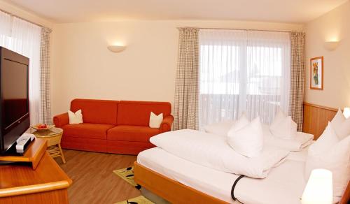 a living room with a bed and a couch at Gasthof Fischerstüberl in Rottau
