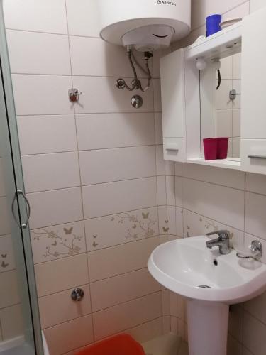 a small bathroom with a sink and a shower at Apartments Victoriya in Sutomore