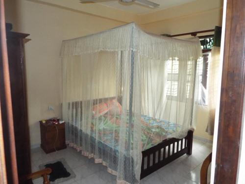 a bedroom with a canopy bed with a window at Ceylon Epic Inn in Bentota