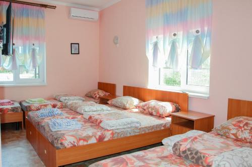 a room with four beds and two windows at Hotel Kings Zatoka in Zatoka