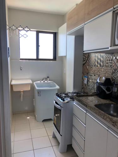 a kitchen with a sink and a stove top oven at Apartamento 02 quartos completo, BEIRA-MAR com piscina in Maceió