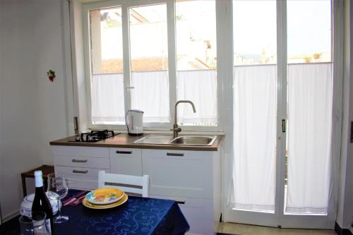 uma pequena cozinha com um lavatório e uma janela em Primavera apartment em Mazzeo