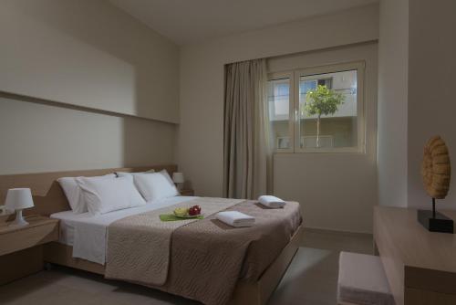 a bedroom with a bed and a window with a fruit on it at Ourania Apartments Hotel in Gouves