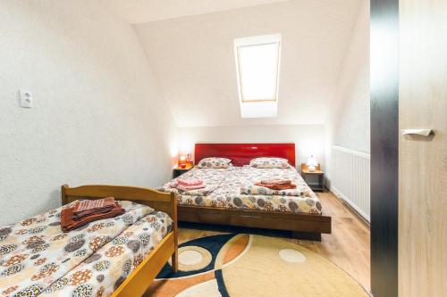 a bedroom with two beds and a window at Erőss Kulcsosház in Lăzarea