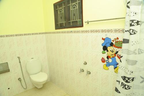 a bathroom with a toilet and a shower curtain at ZuriEL Suite GUEST HOUSE in Coimbatore