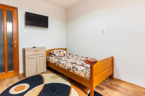 a small bedroom with a bed and a tv at Erőss Kulcsosház in Lăzarea