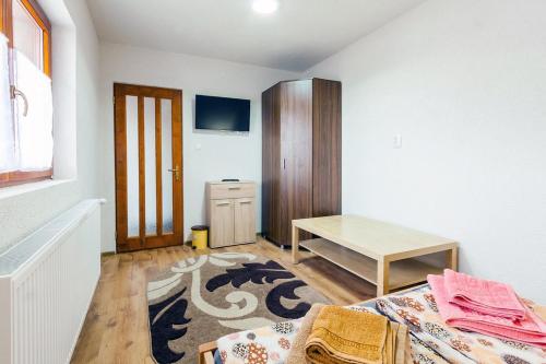 a room with a bed and a table in it at Erőss Kulcsosház in Lăzarea