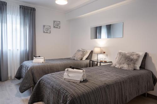 una habitación de hotel con 2 camas y una bolsa en la cama en Home Sweet Home en Ílhavo