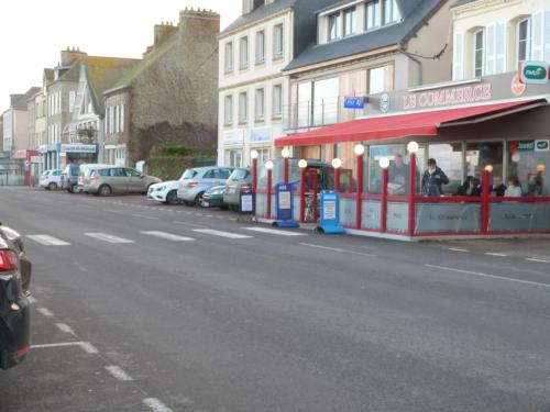 a street with cars parked in front of a store at Quai Vauban in Saint-Vaast-la-Hougue