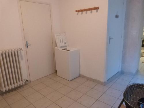 a room with a white refrigerator and a door at Quai Vauban in Saint-Vaast-la-Hougue