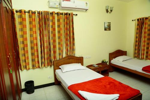 a room with two beds in a room at ZuriEL Suite GUEST HOUSE in Coimbatore