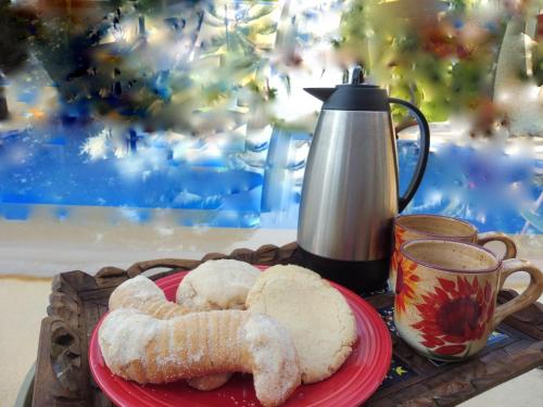 a plate with two pastries and a cup of coffee at Casa de la Costa in Troncones