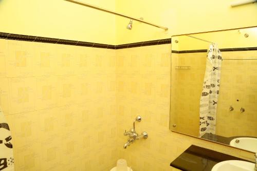 a bathroom with a shower and a sink and a mirror at ZuriEL Suite GUEST HOUSE in Coimbatore