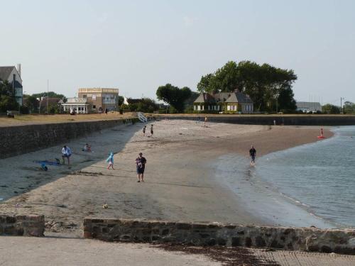 a group of people walking on the beach at Quai Vauban in Saint-Vaast-la-Hougue