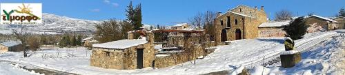 un antiguo edificio de piedra en la nieve con nieve en ΕΥμορφο σαν Παραμύθι ΤΗΛΙΑ en Áno Kalívia