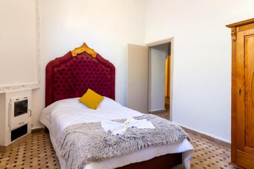 a bedroom with a bed with a red headboard at Villa Ayche in Marrakech