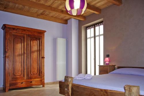 a bedroom with a bed and a large window at Ciabot Besimauda in Peveragno