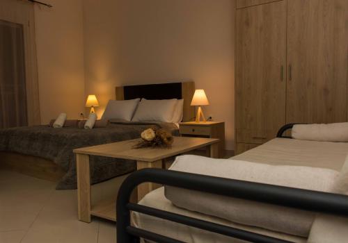 a bedroom with two beds and a table and two lamps at Central Luxury Studio in Korinthos