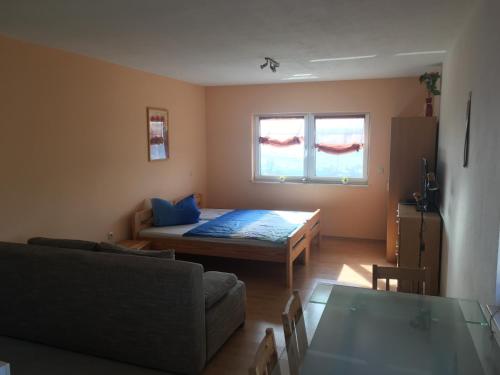 a living room with a bed and a couch at Haus Am Wald in Wasungen