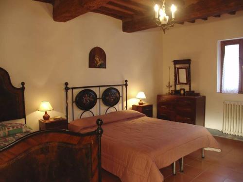 1 dormitorio con 1 cama, 2 mesas y 2 lámparas en Villa Casalunga, en Buonconvento