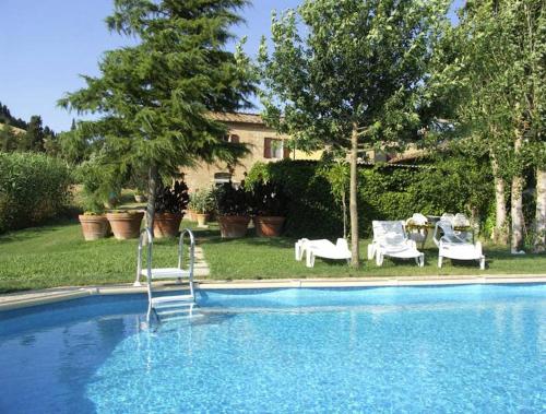 una piscina con 2 sillas, una mesa y sillas en Villa Casalunga, en Buonconvento