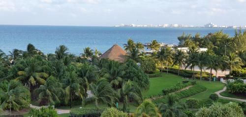 an aerial view of a resort with palm trees and the ocean at Cancun Amara in Cancún