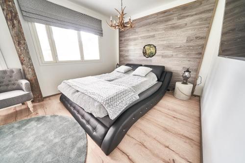 sypialnia z łóżkiem i drewnianą ścianą w obiekcie Apartments Huili w mieście Tahkovuori